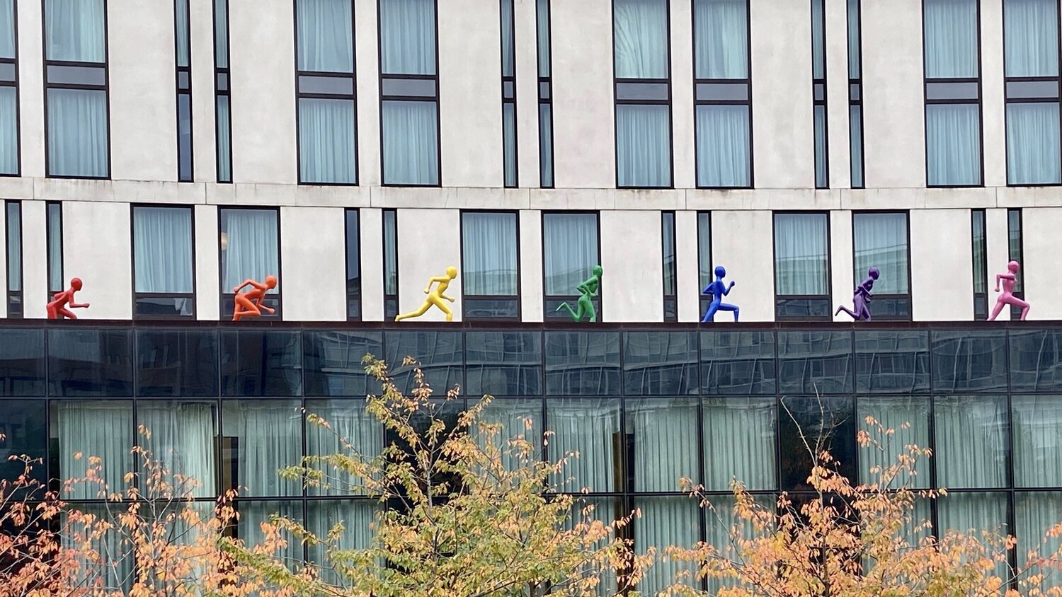 Rainbow running figures on top of a hotel roof