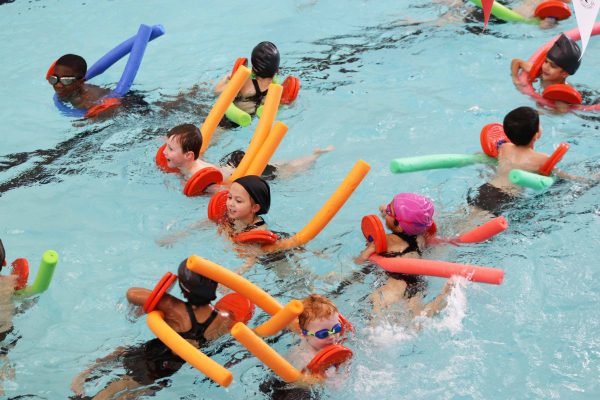 Group of children swimming with arm bands on