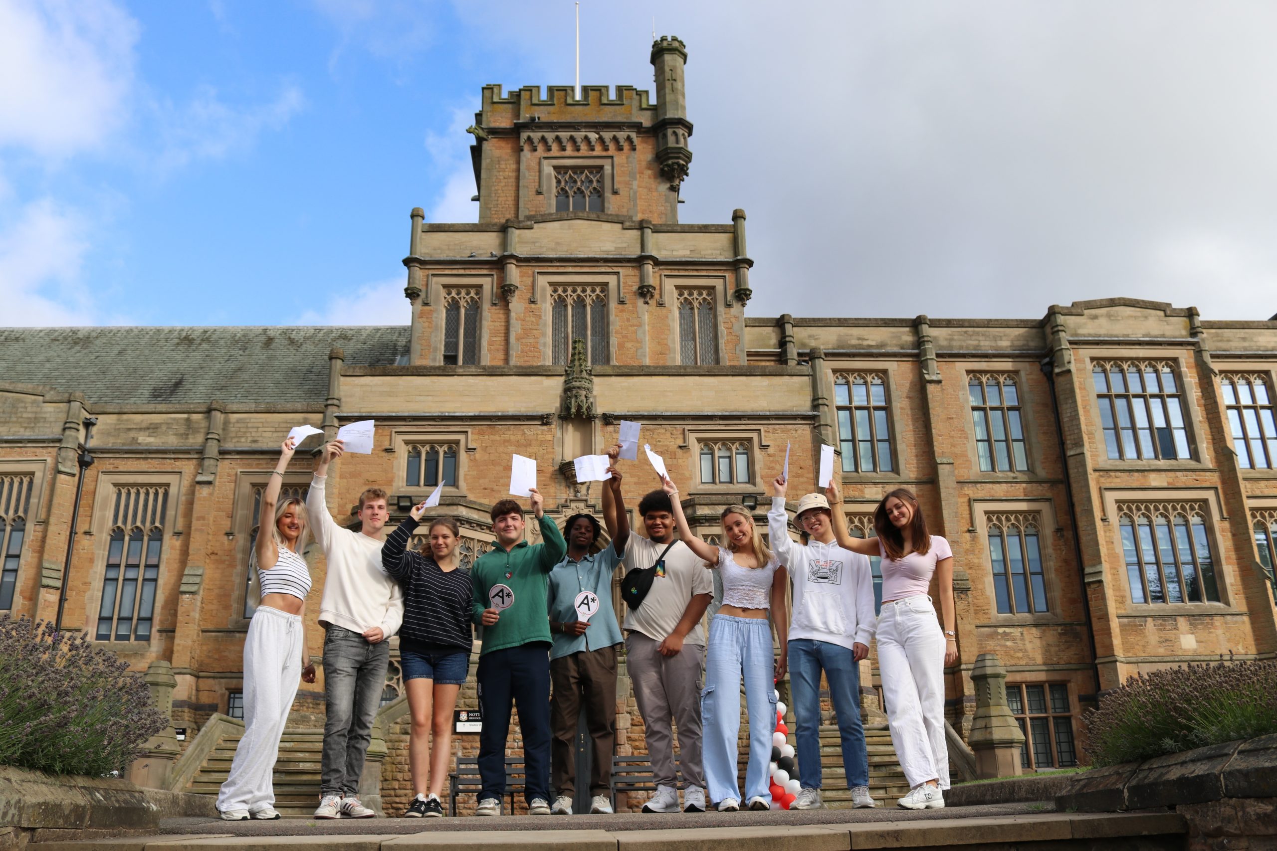 students waving exam results